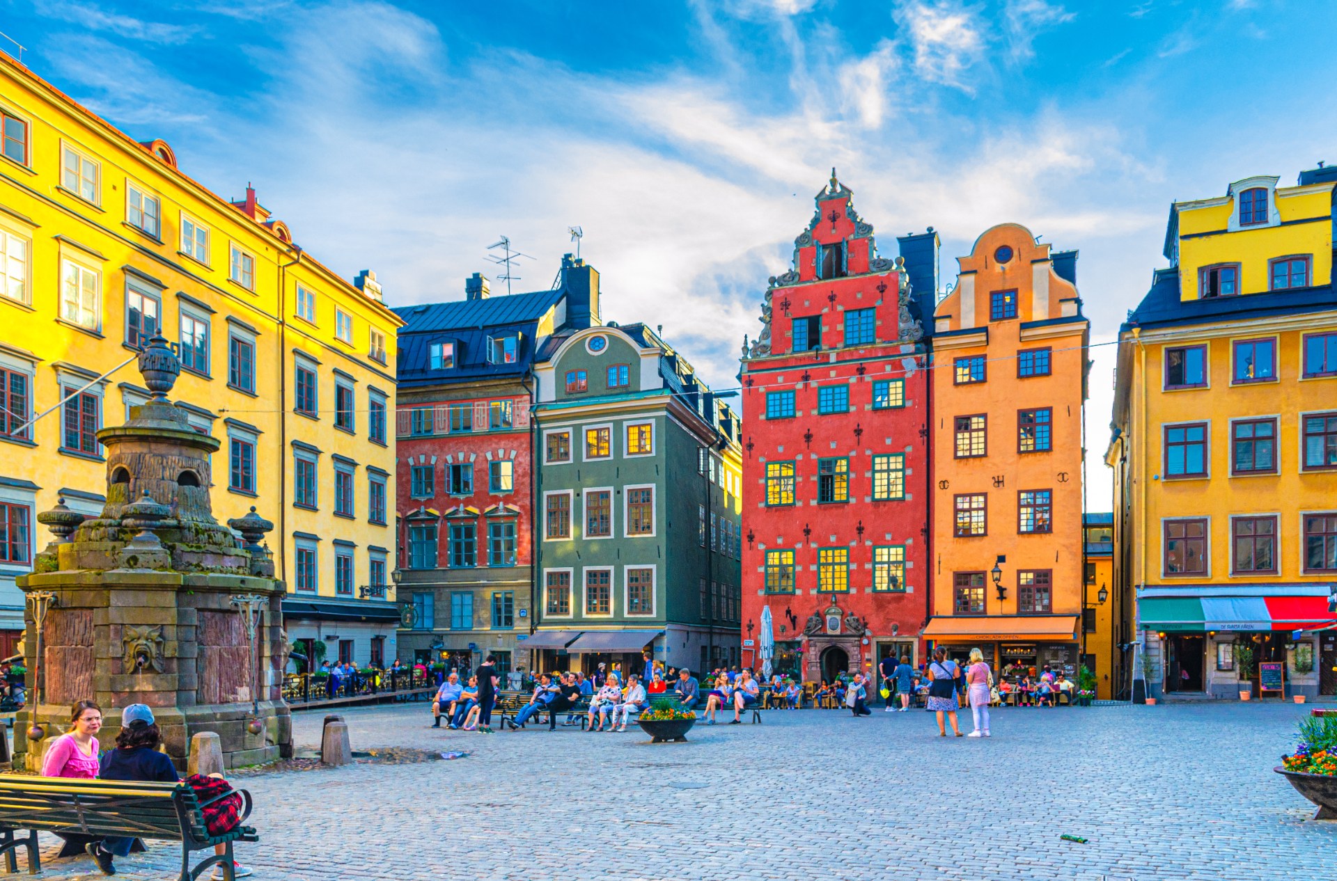 Turisták és járókelők a stockholmi Stortorget téren, színes polgárházak között